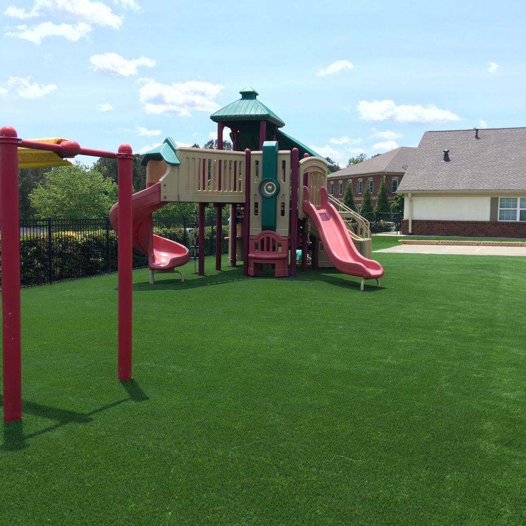 Residential artificial playground grass with red slide