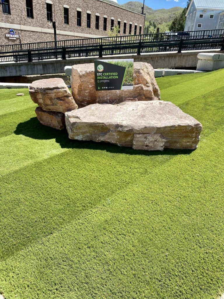 Boulders rested on top of artificial grass lawn