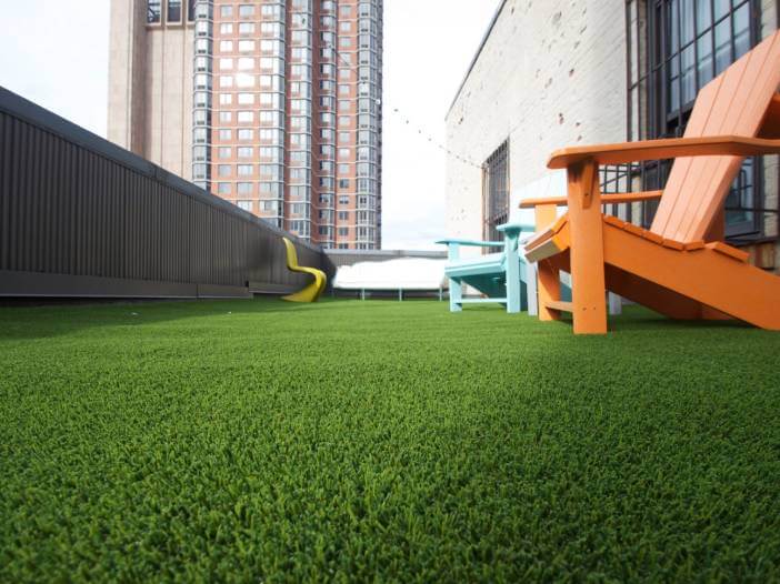 Ground shot of rooftop artificial grass with orange and blue chair